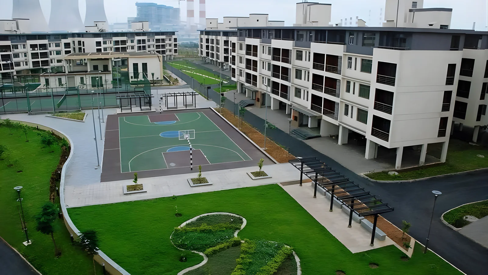 Modern community with landscaped green spaces, sports courts, and sustainable urban infrastructure.